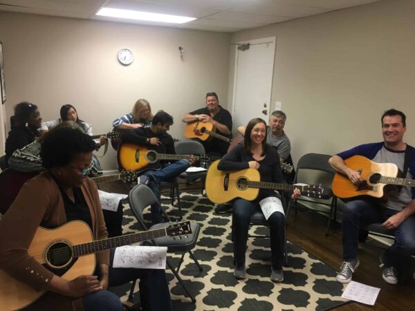 Group of students holding acoustic guitars in a Beginning Guitar Workshop in Nashville