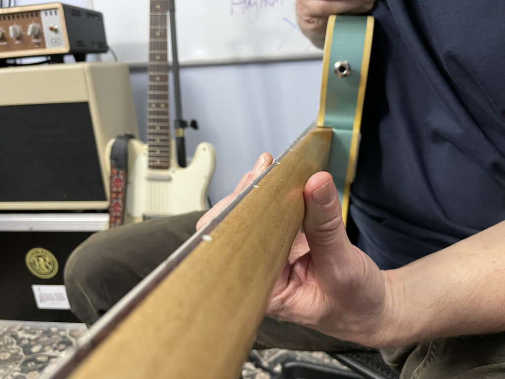 Showing the Thumb Placement on the Back of the Guitar Neck Needed to Play a Barre Chord Without String Buzzing - Green Hills Guitar Studio